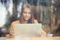 Charming woman looking on laptop during rest in coffee shop, happy Royalty Free Stock Photo