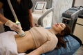 Charming woman receives anti-cellulite and anti-fat therapy in spa salon. Ultrasonic cavitation body contouring treatment