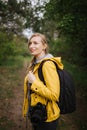 Charming woman standing at forest with backpack and camera Royalty Free Stock Photo