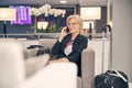 Charming woman talking on mobile phone while waiting for a flight Royalty Free Stock Photo