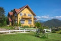 Charming yellow house and a beautiful sky background with garden and mountain in the back