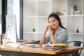 Charming young asian businesswoman sitting at her office desk and smiling to camera Royalty Free Stock Photo