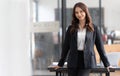 Charming Young Asian businesswoman standing in the office. Looking at camera. Royalty Free Stock Photo