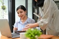 Charming young Asian businesswoman using tablet, working with her colleague Royalty Free Stock Photo