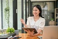 A charming young Asian female office worker is working at her desk in the office Royalty Free Stock Photo