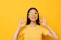 Charming young Asian woman hands gesture emotions cropped view yellow background unaltered Royalty Free Stock Photo