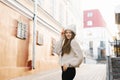Charming young brown-haired woman on a walk. A beautiful and happy woman in a stylish image in a knitted warm hat. Walking around Royalty Free Stock Photo