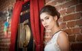 Charming young brunette woman in white lace blouse near a red brick wall. Attractive gorgeous young woman daydreaming Royalty Free Stock Photo