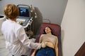 Brunette woman is examined by doctor, undergoes ultrasound examination of abdominal cavity and small pelvic organs on modern