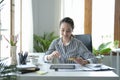 Charming young businesswoman holding credit card and making banking online on digital tablet Royalty Free Stock Photo