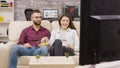 Charming young couple sitting on the couch and watching tv Royalty Free Stock Photo