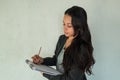 A charming young entrepreneur taking notes in a notebook smiling on a white background Royalty Free Stock Photo