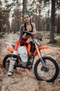 Charming young female racer with semi naked torso sitting on her bike in the woods Royalty Free Stock Photo