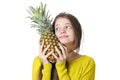 Charming young girl hugs a large ripe pineapple. Royalty Free Stock Photo