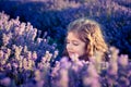 Gorgeous young girl exploring the fragrance of the lavender aroma in the lavender field