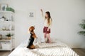 Charming young girl lying on sofa, looking at beagle dog and gives high five. Smiling cute child resting with puppy Royalty Free Stock Photo