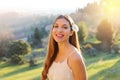 Charming young girl with shy smiling. Photo of beautiful young woman with flower on ear and natural background Royalty Free Stock Photo