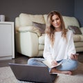 Charming young girl sitting on the floor. To work with notebook, take notes Royalty Free Stock Photo