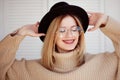 Charming young girl in a stylish hat and glasses. Young woman wearing braces and smiling. Royalty Free Stock Photo