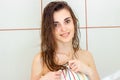 A charming young girl with wet hair sitting in the bathroom in a towel and smiling Royalty Free Stock Photo