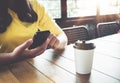 Charming young hipster girl hands using on her smart phone sitting at wooden table in a coffee shop Royalty Free Stock Photo