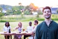 Charming Young Man Relishing Sunny BBQ Gathering with Friends