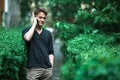 Charming young man talking on mobile phone outdoors. Royalty Free Stock Photo