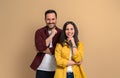 Charming young man and woman with hands on chins smiling and looking at camera. Confident joyful boyfriend and girlfriend wearing