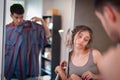 A young man and a woman choose shirts for him