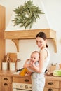 Charming young mother with a baby in a stylish fashionable kitchen Royalty Free Stock Photo