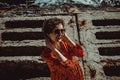 Charming young smiling woman in red dress with short curly hair looking at camera. Female retro sun protection sunglasses. Enjoy Royalty Free Stock Photo