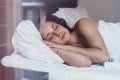 Beautiful young woman wakes up in her bed fully rested. A woman with a gentle smile in bed after waking up.