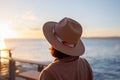 charming young woman in a coat and hat, looking at the sunset. The girl looks at the sea Royalty Free Stock Photo