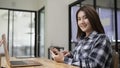 Young woman holding mobile phone and smiling to camera. Royalty Free Stock Photo