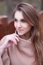 Charming young woman with long brown hair in a beige coat Royalty Free Stock Photo