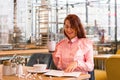 Charming young woman in pink shirt enjoying eating breakfast at cafe Royalty Free Stock Photo