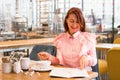 Charming young woman in pink shirt enjoying eating breakfast at cafe Royalty Free Stock Photo