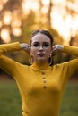 Charming young woman standing in autumnal park