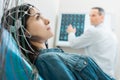 Charming young woman undergoing electroencephalography