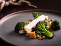 Charred tenderstem broccoli with cheese a quince terrine and hazelnuts. Royalty Free Stock Photo