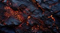 Charred volcanic surface with glowing orange cracks. Royalty Free Stock Photo