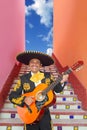 Charro Mariachi playing guitar in Mexico stairway