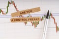 On the chart of business quotes lies a pen and torn paper with the inscription - Are You a Control Freak