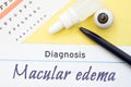 Chart for testing visual acuity, eye drops and anatomical model lies next to inscription Diagnosis Macular Edema. Concept for diag