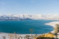 Charvak reservoir in Uzbekistan in winter with blue water in it, surrounded by the Tien Shan mountain system Royalty Free Stock Photo