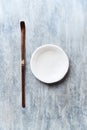 Chashaku Matcha spoon and empty ceramics plate on rustic wooden background.