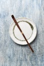 Chashaku Matcha spoon and empty ceramics plate on rustic wooden background.