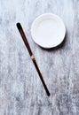 Chashaku Matcha spoon and empty ceramics plate on rustic wooden background.