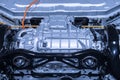 Chassis of the electric car with powertrain and power connections closeup. Blue toned. EV car drivetrain at maintenance. Royalty Free Stock Photo