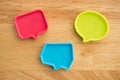 Chat bubbles on social media communication. Red, green and blue chat bubbles icon messages on wooden background minimal style.